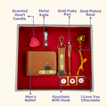 A box showcasing customized leather wallet, keychain, gold flaked pen, metal kada, scented candle with a gold plated rose and higlighting their features. Perfect for valentines gifting.