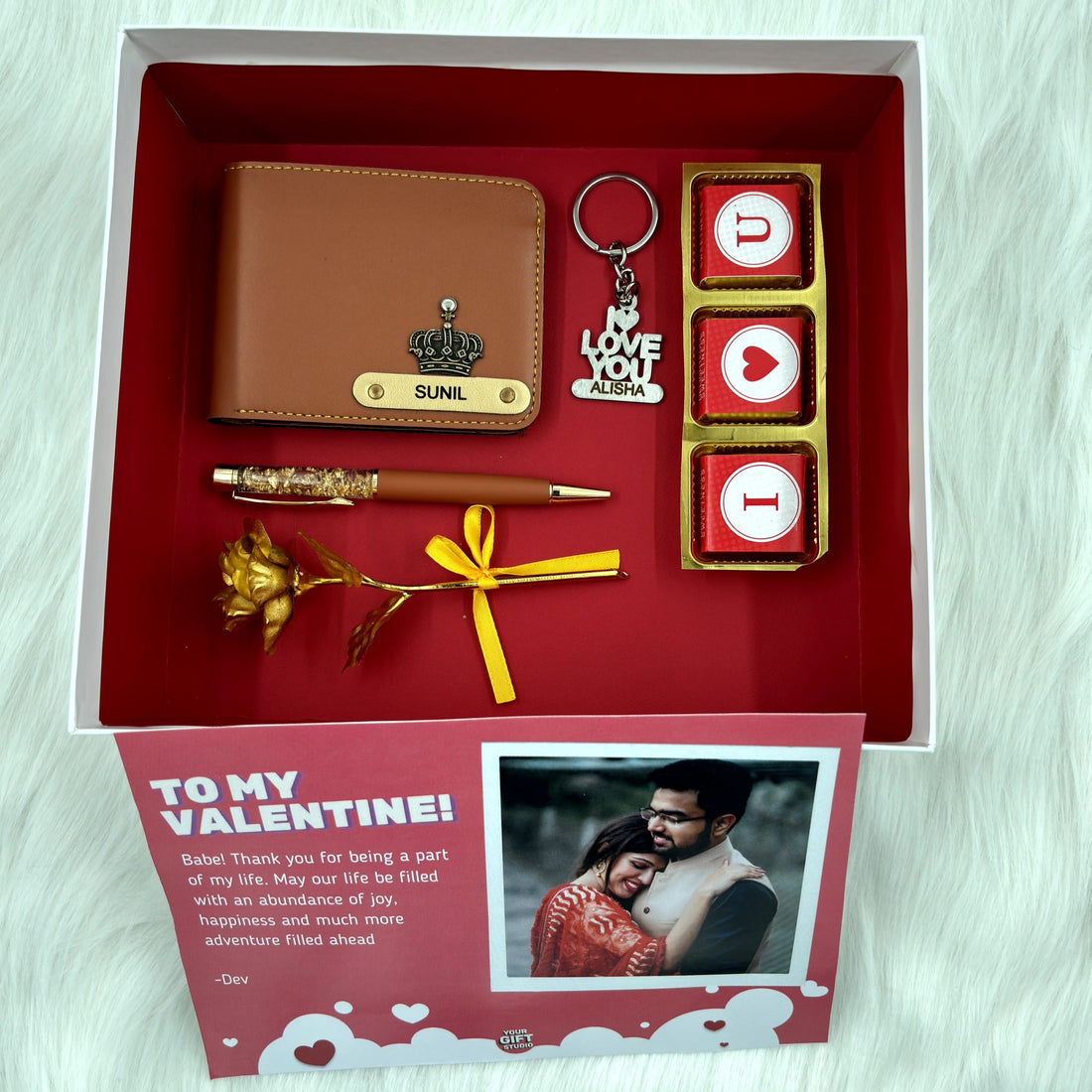 A box showcasing leather wallet, I Love You chocolate &  keychain, gold flaked pen, along with a gold rose, higlighting their features. Perfect for valentines gifting.