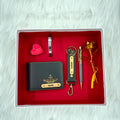 A top view of a box containing customized grey leather wallet, keychain, gold flake pen, kada, scented candle and gold plated rose.