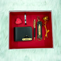 A top view of a box containing customized black leather wallet, keychain, gold flake pen, kada, scented candle and gold plated rose.