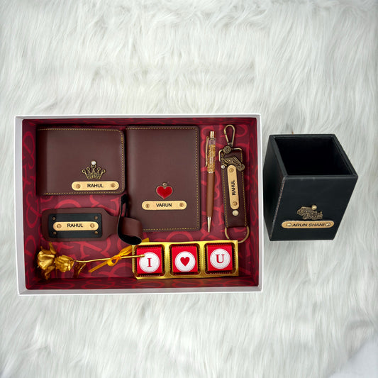 A top view of a box containing customized leather wallet, passport cover, luggage tag, I Love You chocolate, along with a gold rose, keychain and a leather box