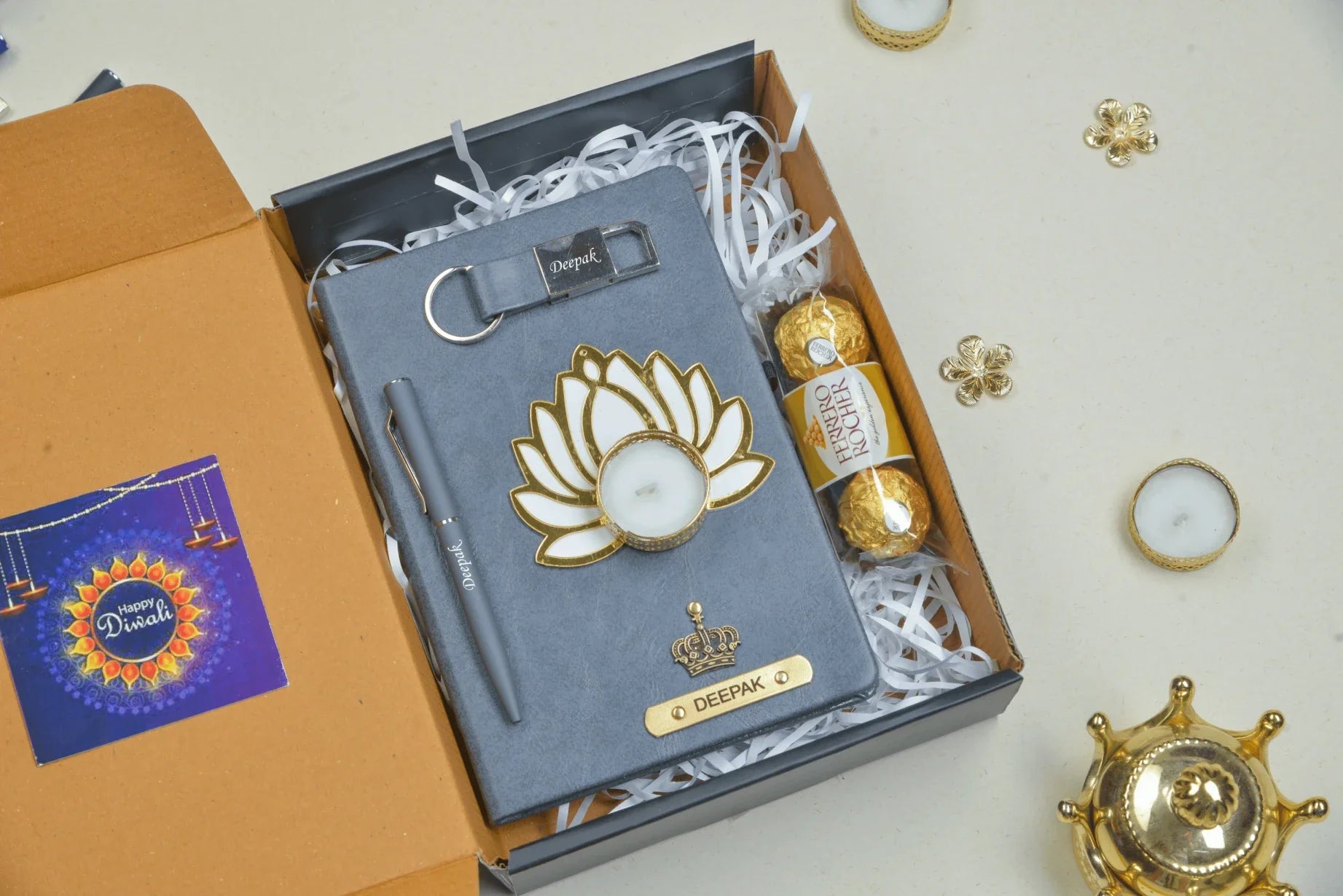 Make this Diwali unforgettable with our customizable Diwali combo. This set includes a premium quality diary, a beautifully crafted keychain, a traditional diya to spread light and joy, a selection of delicious chocolates, and a high-quality pen, all personalized with your unique message and design.